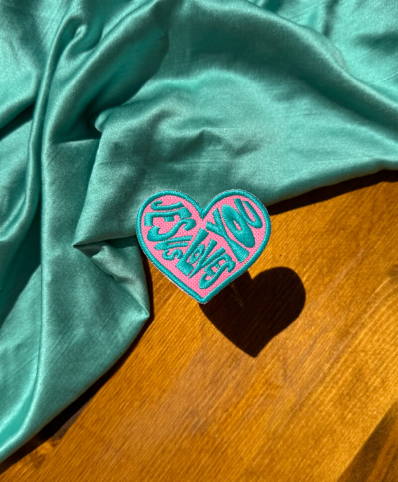 teal and pink trucker hat patch jesus loves you black and white patch